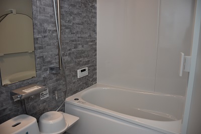 左側がグレー、右側が白の壁で作られた風呂場の写真