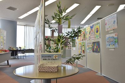 ポスターが貼られた2つのパネルの間に短冊のかかった笹が飾られている写真