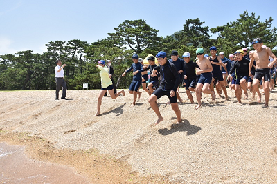 水着姿の子供たちが海に向かって駆け出している写真