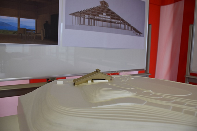 資料の貼られたホワイトボードの前に建築模型が置かれている写真