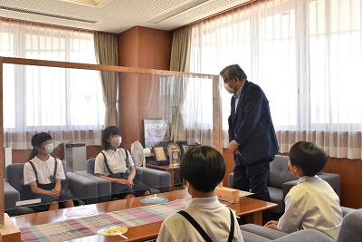 立ち上がった男性を見つめる児童4人の写真