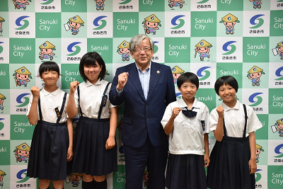 男性と児童4人が並んでガッツポーズを取っている写真