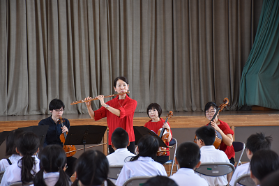 女性が立ってフルートを吹いている写真