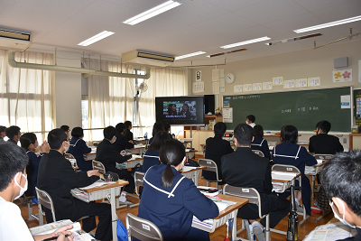 教室に設置されたモニターに映し出された動画を見る生徒たちの写真