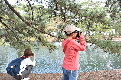川辺で撮影を行う親子の写真