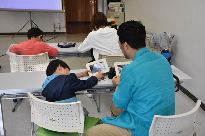 現像された写真を見せ合う親子の写真