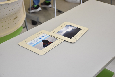 現像された空と海辺の写真2枚が長机に置かれた写真