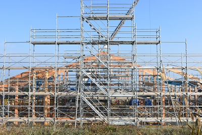 建物状に組まれた木組の周りに足場が組まれている写真