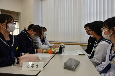 2年生の生徒6人が机で話し合っている写真