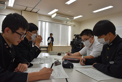 男子生徒4人が用紙に書き込んでいる写真