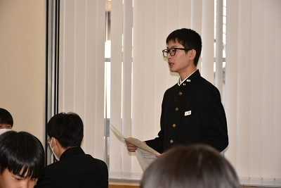 生徒が用紙を持ちながら発表している写真