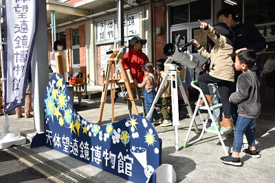 「天体望遠博物館」と書かれた看板と共に設置された望遠鏡の写真