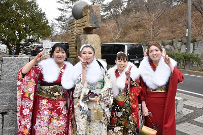 振り袖にショールを着用した女性4人が並んでいる写真