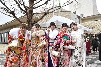 5人の振り袖姿の女性が並んでピースサインしている写真