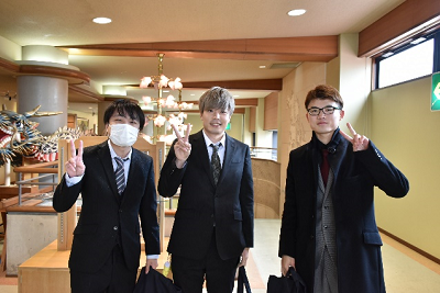 室内でスーツ姿の男性3人が並んでいる写真