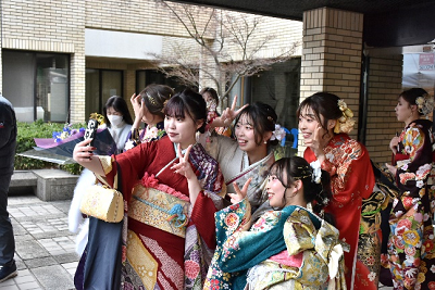 振り袖姿の女性たちがスマートフォンで自撮りしている写真