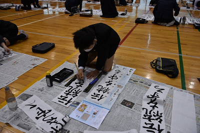 児童が書初めで「伝統を守る」と書いている写真