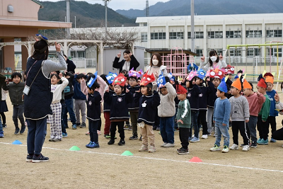 手作りの鬼のお面を付けた園児たちが屋外で整列している写真