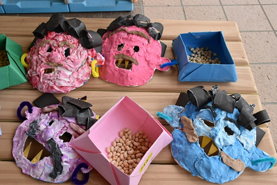 手作りの鬼のお面と紙箱の中に入った豆の写真