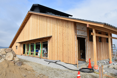 窓に薄緑色のテープが張られている建設中の建物の写真