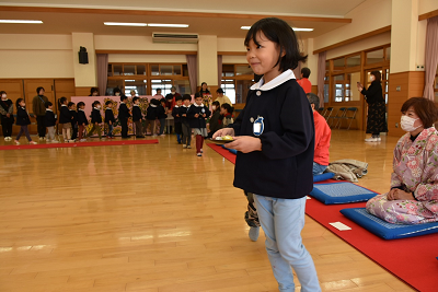 和菓子を手に歩く女子園児の写真