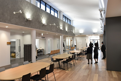 楕円形のテーブルが置かれた室内を見学している人の写真