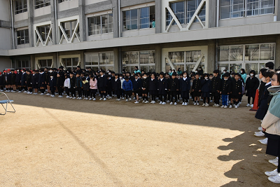 校舎の前に固まって並ぶ児童達の写真