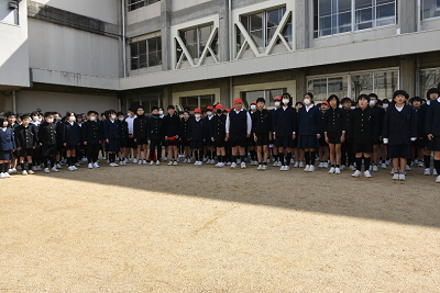 校舎の前に固まって並ぶブレザー姿の児童達の写真