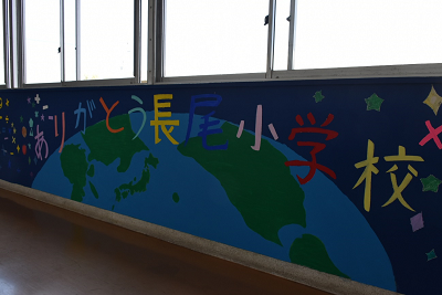 地球とメッセージがペイントされた校舎の壁の写真