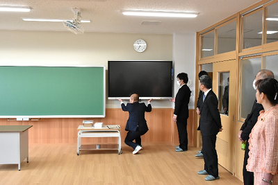 男性が教室のテレビの位置を直している写真