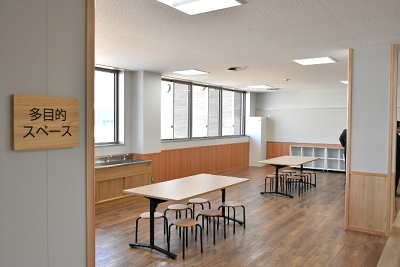 机と椅子が置いてある多目的スペースの写真