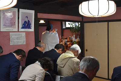 祈っている神主の前で軽く頭を下げている人たちの写真