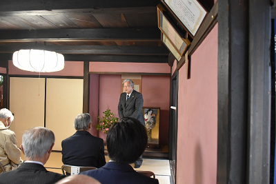 男性が座っている人達の前で話している写真