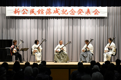 並んで座り、三味線を演奏する男女5人の写真