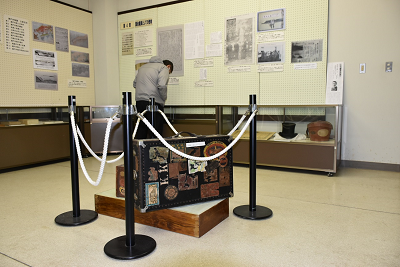 背の低いショーケースに入っている展示を見ている男性の写真