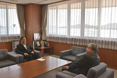 応接室で男性2人が向かい合って談笑している写真