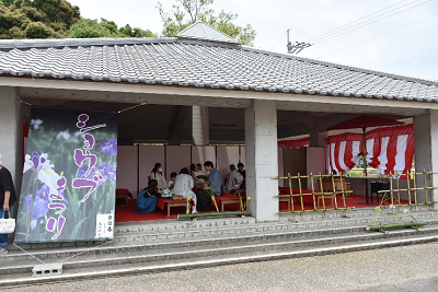 瓦屋根の東屋に人々が座っている写真