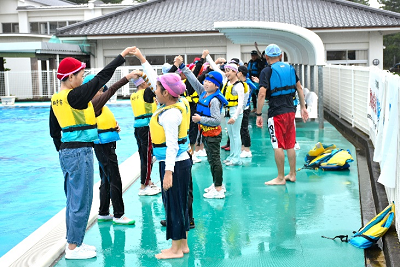 2人組でつないだ手を上にあげる児童達の写真