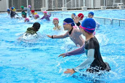 着衣のままプールに入る児童達の写真