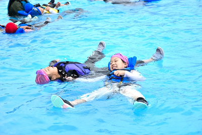 ライフジャケットを着用して水面に浮かぶ児童2人の写真