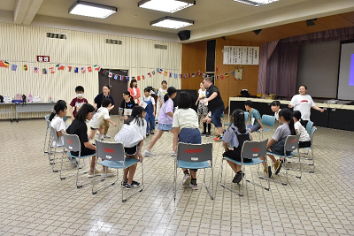 円になるように並べた椅子から立ち上がる児童たちの写真