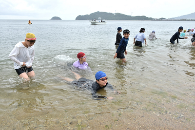 海に入って遊ぶ児童達の写真