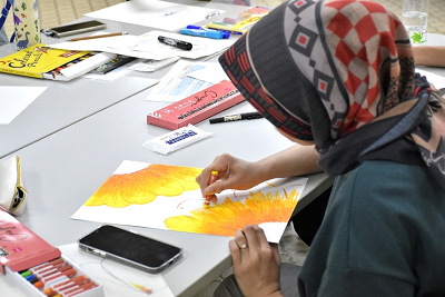 黄色い花のイラストを描いている人の写真