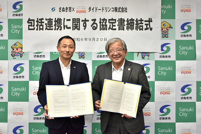 手に持った書類を見せている男性2人の写真