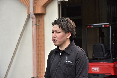 黒いシャツを着た男性が話している写真