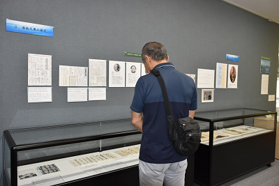 背の低いショーケースを見ている男性の写真