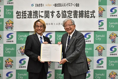 書類を一緒に持つ男性2人の写真