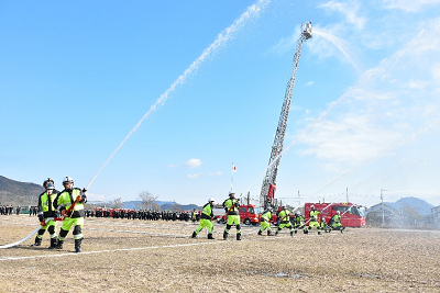 2人1組になってホースを構え、上に向かって水を噴射している写真