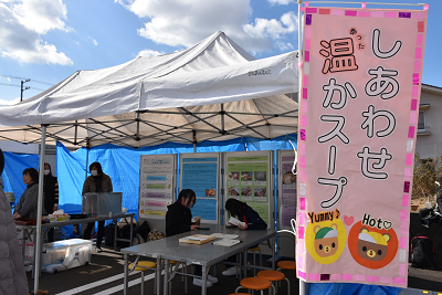 テントの前にスープの宣伝のぼりが置かれている写真