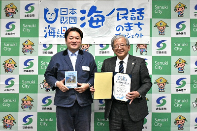 書類やパンフレットを持った2人の男性が並んでいる写真